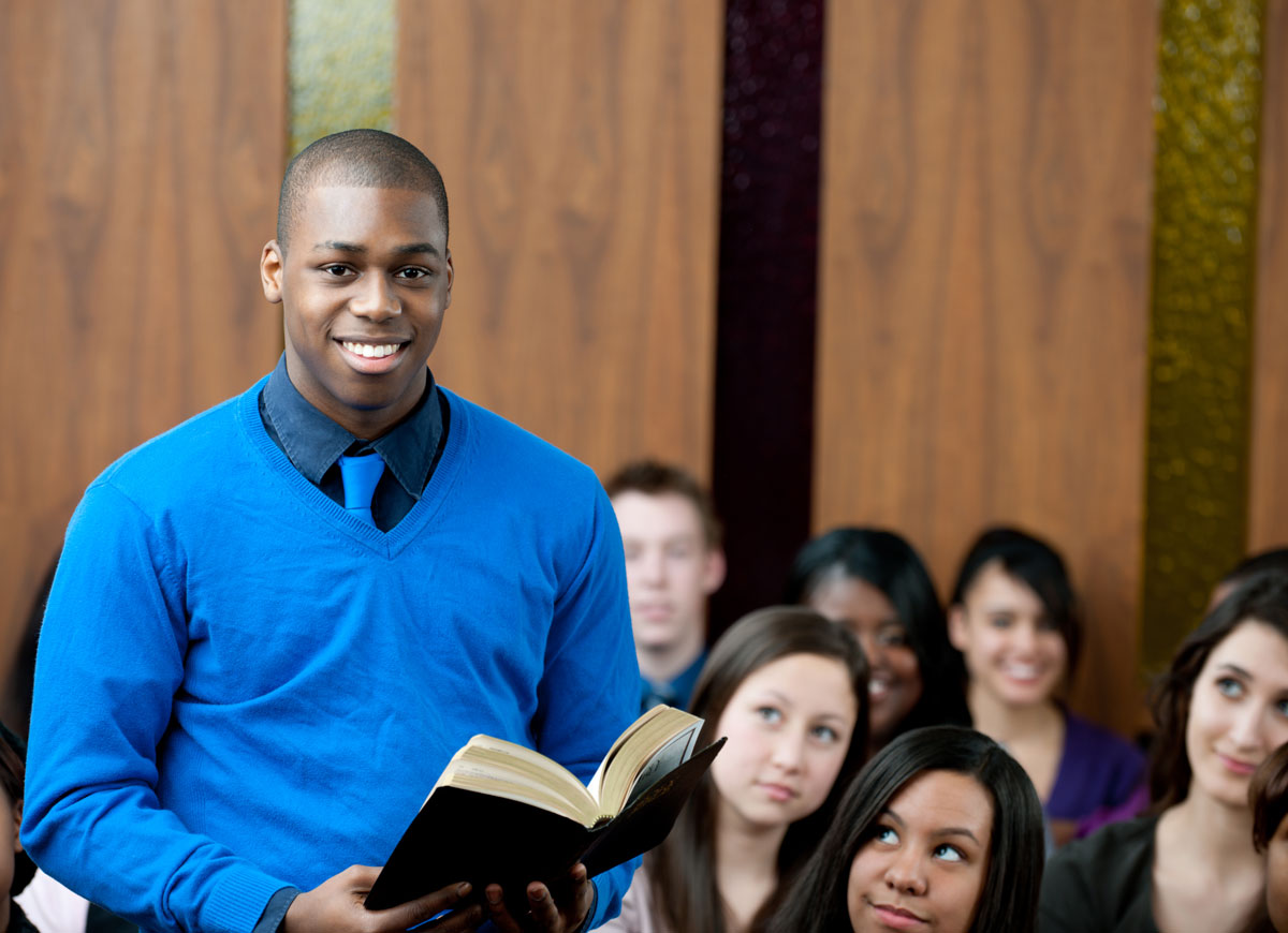 Young man standing in church holding the Bible